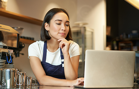 A barista looking at her banks statements online through Stellar's online banking service