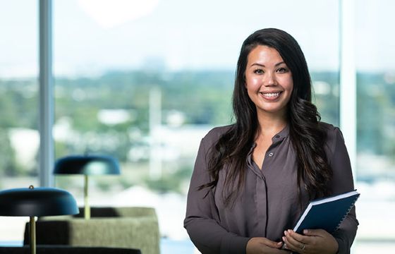 A female Stellar Bank accountant holding a spiral notebook