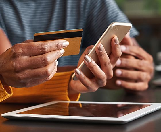 Hand holding mobile phone and debit card