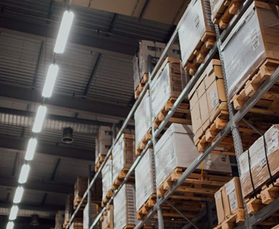 Stacks of boxes and packages buddled up on crates sitting in a warehouse