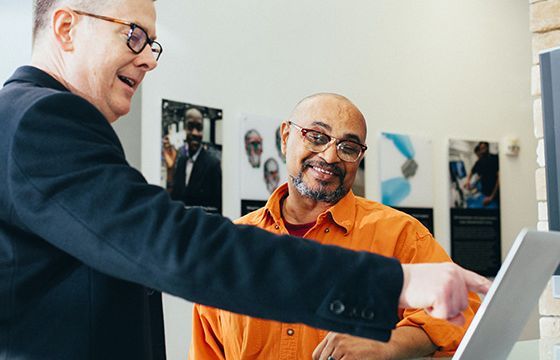 A Stellar Bank expert walking a client through treasury management services on a laptop