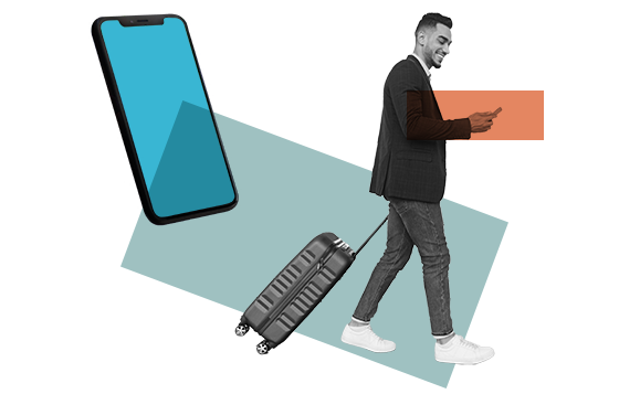 A man checking his phone as he pulls his luggage along