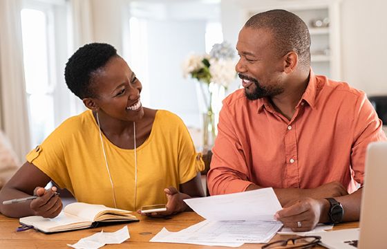 A married couple looking over their finances at table