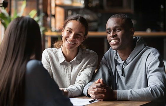 A Stellar Bank teller talking to a couple about opening a personal savings account