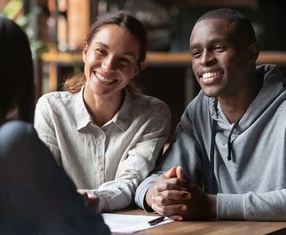 A Stellar Bank teller talking to a couple about opening a personal savings account