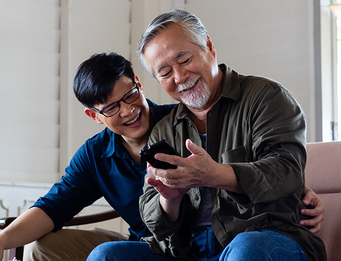 An Asian father and son exploring mobile banking with the Stellar on an iphone