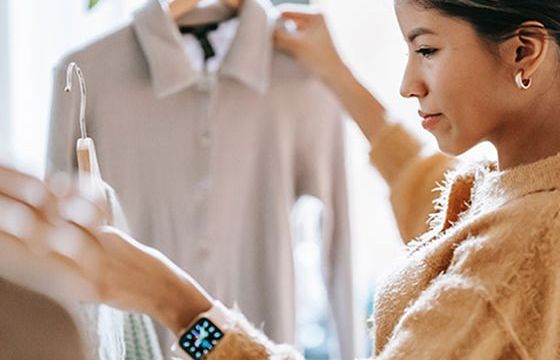 A woman comparing shirts in a store