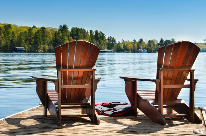 Two deck chairs resting in the sun on a pier