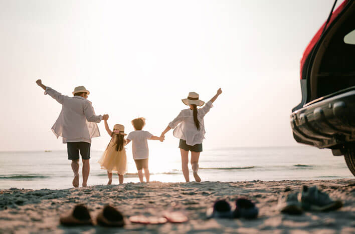 A family holding hands on the beach in the late afternoon sun