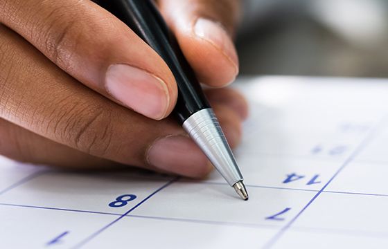 A pen about to write something down on a calendar